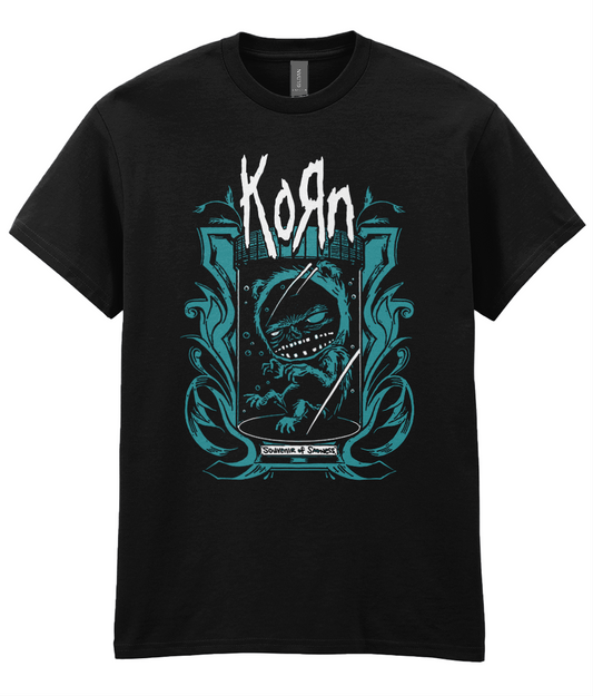 A black short-sleeve crewneck t-shirt featuring a graphic print of the band Korn. The design includes the band's name in a stylized white font above a teal and white illustration of a skull inside a castle-like crest.