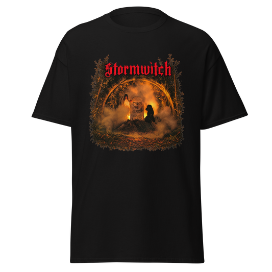 A black short-sleeve graphic t-shirt featuring the band name 'Stormwitch' in red gothic lettering above a circular, fiery, and smoky illustration with a dark figure silhouette.