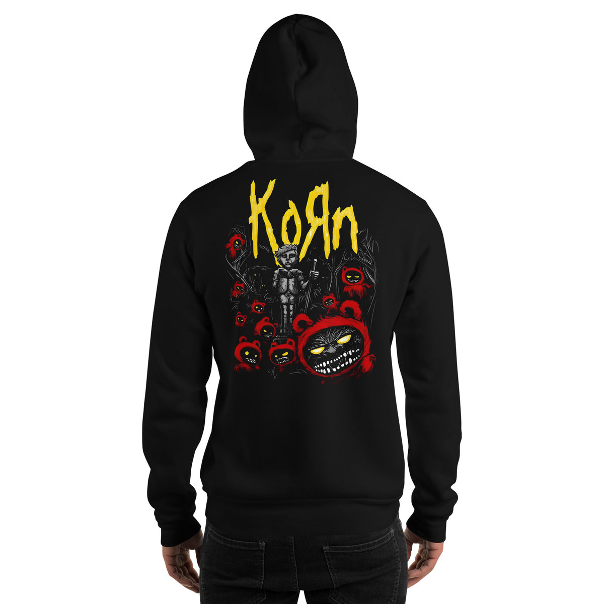 A person shown from the back wearing a black hoodie with a large back graphic featuring the word Korn in yellow and red horror-themed artwork, against a plain white background.